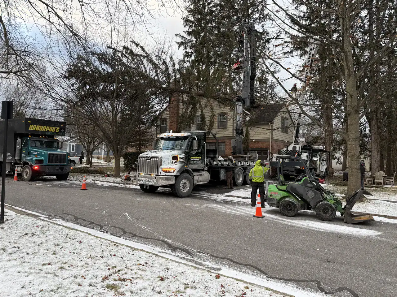 Arbor Pro's crew with traffic cones and hi-vis flagger during a residential crane tree removal in Central PA